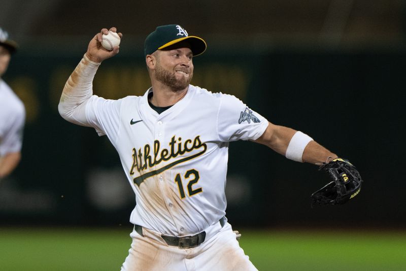 Jul 5, 2024; Oakland, California, USA;  Oakland Athletics shortstop Max Schuemann (12) throws the ball during the ninth inning against the Baltimore Orioles at Oakland-Alameda County Coliseum. Mandatory Credit: Stan Szeto-USA TODAY Sports