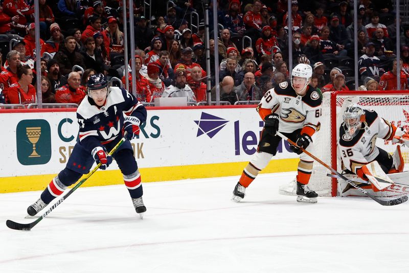 Jan 16, 2024; Washington, District of Columbia, USA; Washington Capitals right wing T.J. Oshie (77) skates with the puck behind Anaheim Ducks goaltender John Gibson (36) as Ducks defenseman Jackson LaCombe (60) chases in the first period at Capital One Arena. Mandatory Credit: Geoff Burke-USA TODAY Sports