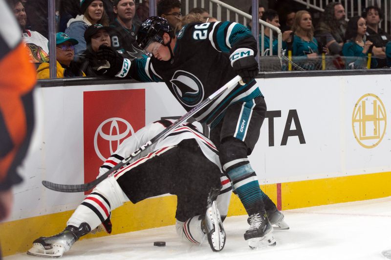 Oct 31, 2024; San Jose, California, USA; San Jose Sharks defenseman Jack Thomas (26) battles Chicago Blackhawks left winger Nick Foligno (17) for the puck during the first period at SAP Center at San Jose. Mandatory Credit: D. Ross Cameron-Imagn Images