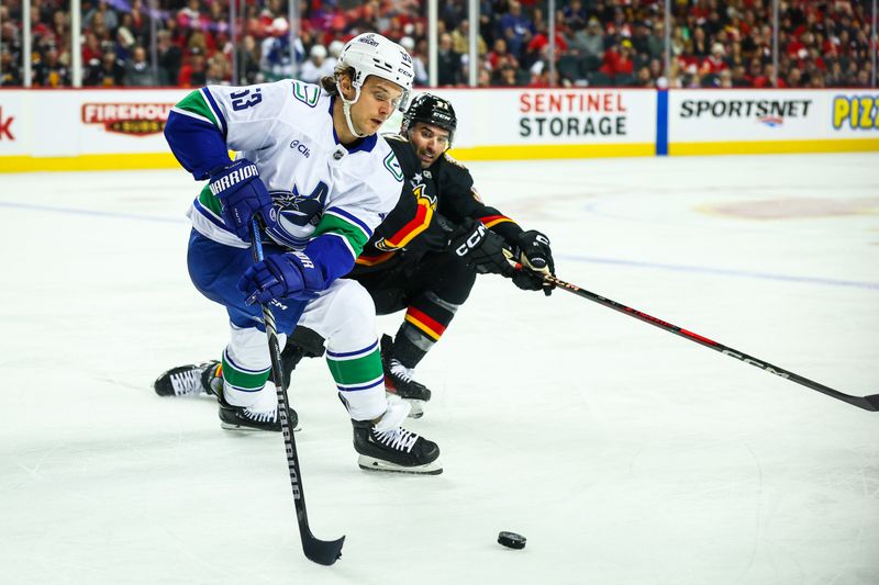 Dec 31, 2024; Calgary, Alberta, CAN; Vancouver Canucks center Teddy Blueger (53) controls the puck against Calgary Flames center Nazem Kadri (91) during the second period at Scotiabank Saddledome. Mandatory Credit: Sergei Belski-Imagn Images