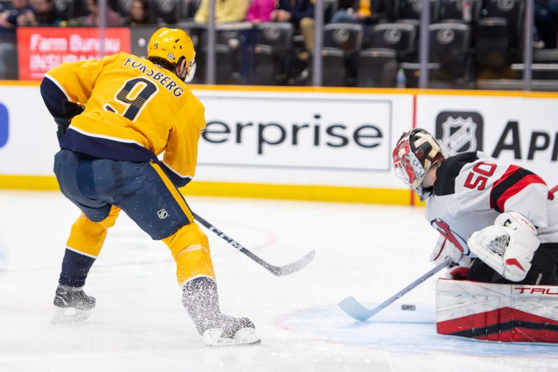 Feb 13, 2024; Nashville, Tennessee, USA;  New Jersey Devils goaltender Nico Daws (50) blocks the shot of Nashville Predators left wing Filip Forsberg (9) during the third period at Bridgestone Arena. Mandatory Credit: Steve Roberts-USA TODAY Sports