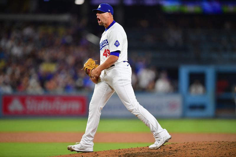 Aug 29, 2024; Los Angeles, California, USA; Los Angeles Dodgers pitcher Blake Treinen (49) reacts following the seventh inning against the Baltimore Orioles at Dodger Stadium. Mandatory Credit: Gary A. Vasquez-USA TODAY Sports