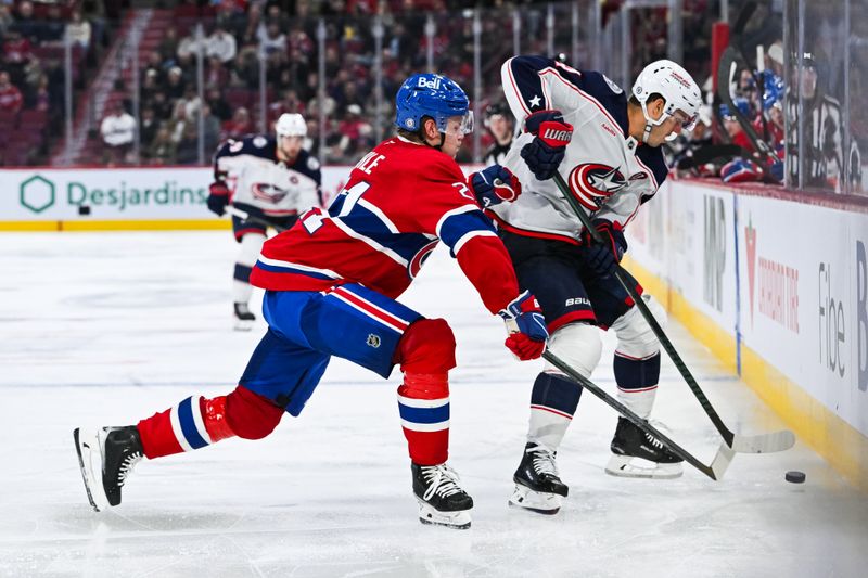 Nov 16, 2024; Montreal, Quebec, CAN; Montreal Canadiens defenseman Kaiden Guhle (21) defends the puck against Columbus Blue Jackets center Cole Sillinger (4) near the boards during the third period at Bell Centre. Mandatory Credit: David Kirouac-Imagn Images