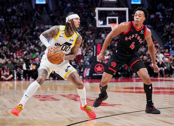 TORONTO, ON - DECEMBER 23: Jordan Clarkson #00 of the Utah Jazz drives against Scottie Barnes #4 of the Toronto Raptors during the second half of their basketball game at the Scotiabank Arena on December 23, 2023 in Toronto, Ontario, Canada. NOTE TO USER: User expressly acknowledges and agrees that, by downloading and/or using this Photograph, user is consenting to the terms and conditions of the Getty Images License Agreement. (Photo by Mark Blinch/Getty Images)