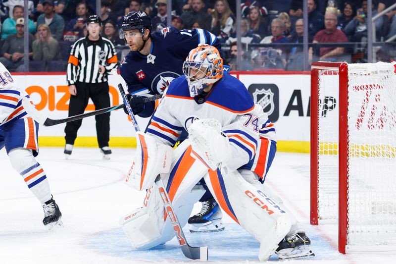 Sep 25, 2024; Winnipeg, Manitoba, CAN; Edmonton Oilers goalie Stuart Skinner (74) and Winnipeg Jets forward Gabriel Vilardi (13) look for the puck during the second  period at Canada Life Centre. Mandatory Credit: Terrence Lee-Imagn Images