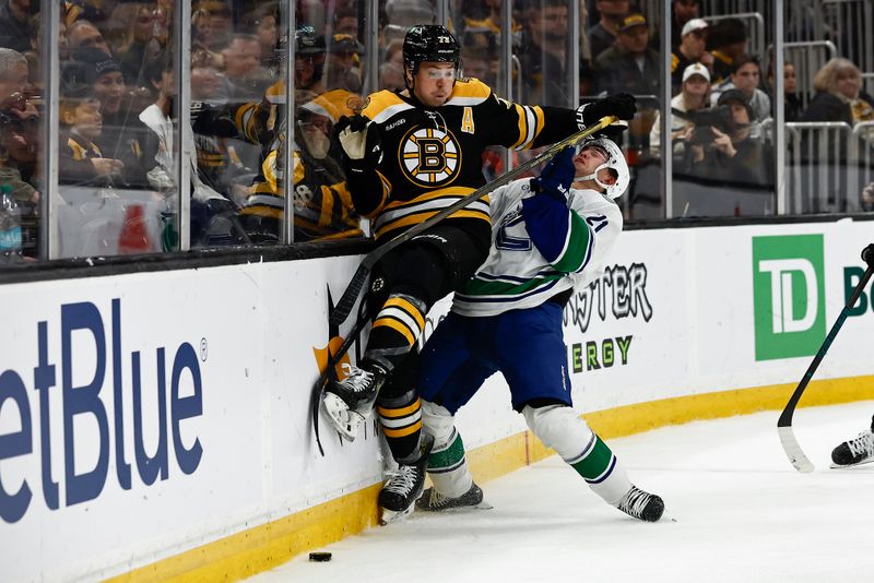 Nov 26, 2024; Boston, Massachusetts, USA; Boston Bruins defenseman Charlie McAvoy (73) collides with Vancouver Canucks left wing Nils Hoglander (21) going for a loose puck during the second period at TD Garden. Mandatory Credit: Winslow Townson-Imagn Images