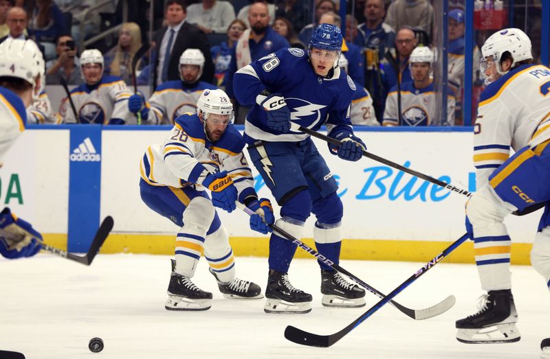 Apr 15, 2024; Tampa, Florida, USA;  Tampa Bay Lightning defenseman Emil Lilleberg (78) passes the puck as Buffalo Sabres left wing Zemgus Girgensons (28) defends during the first period at Amalie Arena. Mandatory Credit: Kim Klement Neitzel-USA TODAY Sports