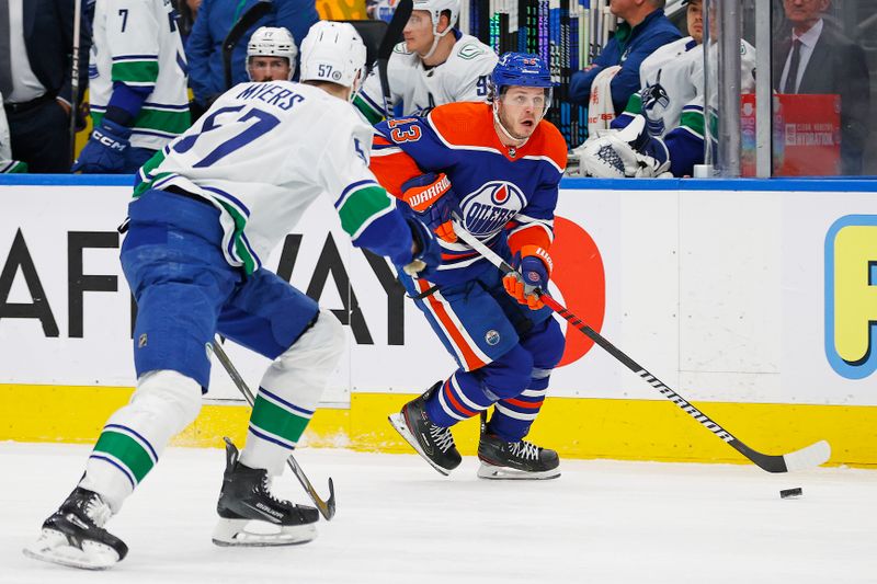 Apr 13, 2024; Edmonton, Alberta, CAN; Edmonton Oilers forward Mattias Janmark (13) looks to make a pass in front of Vancouver Canucks defensemen Tyler Myers (57) during the first period at Rogers Place. Mandatory Credit: Perry Nelson-USA TODAY Sports