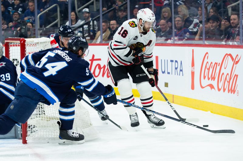 Jan 11, 2024; Winnipeg, Manitoba, CAN; Winnipeg Jets defenseman Dylan Samberg (54) tries to check Chicago Blackhawks forward Jason Dickinson (16) during the first period at Canada Life Centre. Mandatory Credit: Terrence Lee-USA TODAY Sports