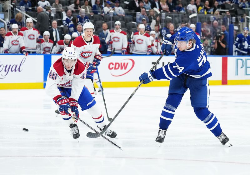 Oct 8, 2025; Toronto, Ontario, CAN; Toronto Maple Leafs center Bobby McMann (74) shoots the puck as Montreal Canadiens defenseman Lane Hutson (48) tries to defend during the third period at Scotiabank Arena. Mandatory Credit: Nick Turchiaro-Imagn Images
