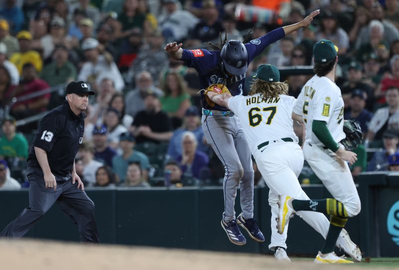 May 5, 2025; West Sacramento, California, USA; Athletics pitcher Grant Holman (67) tags Seattle Mariners shortstop J.P. Crawford (3) for an out during the seventh inning at Sutter Health Park. Mandatory Credit: Dennis Lee-Imagn Images