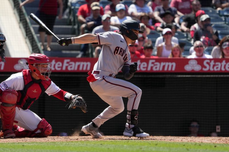 Jul 2, 2023; Anaheim, California, USA; Arizona Diamondbacks left fielder Corbin Carroll (7) hits a single as Los Angeles Angels catcher Matt Thaiss (21) watches in the ninth inning at Angel Stadium. Mandatory Credit: Kirby Lee-USA TODAY Sports