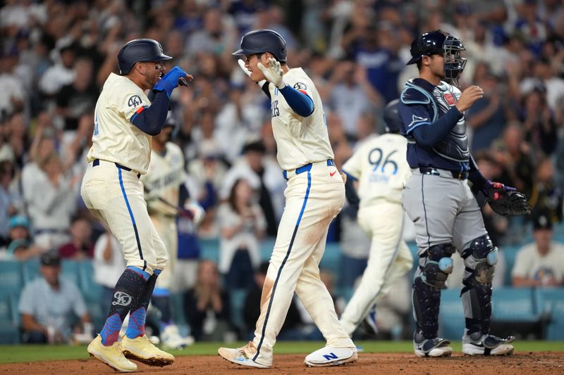 Aug 24, 2024; Los Angeles, California, USA; Los Angeles Dodgers designated hitter Shohei Ohtani (17) celebrates with shortstop Miguel Rojas (11) after hitting a two-run home run in the fifth inning as Tampa Bay Rays catcher Alex Jackson (28) watches at Dodger Stadium. Mandatory Credit: Kirby Lee-USA TODAY Sports