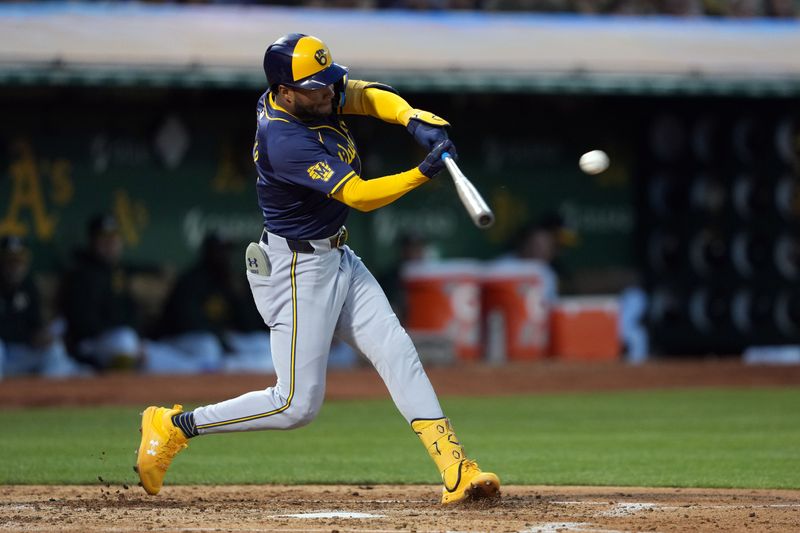 Aug 23, 2024; Oakland, California, USA; Milwaukee Brewers left fielder Jackson Chourio (11) hits an RBI double against the Oakland Athletics during the fourth inning at Oakland-Alameda County Coliseum. Mandatory Credit: Darren Yamashita-USA TODAY Sports