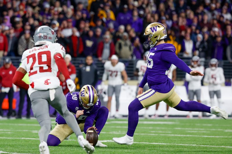 Nov 25, 2023; Seattle, Washington, USA; Washington Huskies place kicker Grady Gross (95) kicks a game-winning field goal against the Washington State Cougars during the fourth quarter at Alaska Airlines Field at Husky Stadium. Washington Huskies punter Jack McCallister (38) holds the ball on the attempt. Washington defeated Washington State, 24-21.  Mandatory Credit: Joe Nicholson-USA TODAY Sports