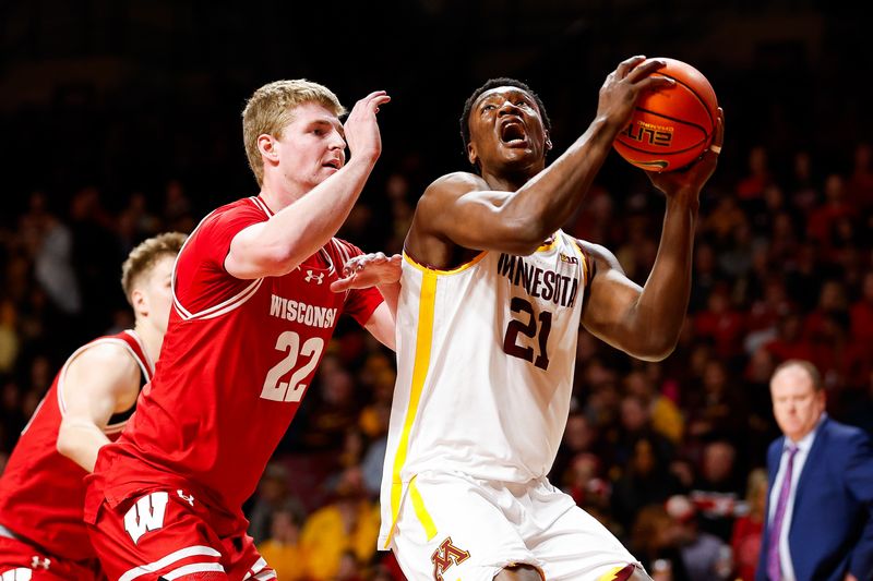 Jan 23, 2024; Minneapolis, Minnesota, USA; Minnesota Golden Gophers forward Pharrel Payne (21) works towards the basket as Wisconsin Badgers forward Steven Crowl (22) defends during the first half at Williams Arena. Mandatory Credit: Matt Krohn-USA TODAY Sports