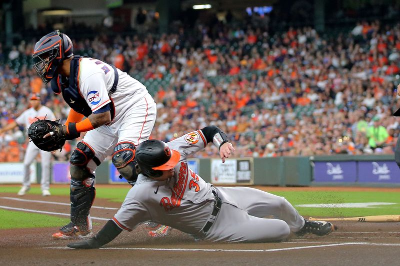 Sep 20, 2023; Houston, Texas, USA; Baltimore Orioles catcher Adley Rutschman (35) slides across home plate to score a run against the Houston Astros during the first inning at Minute Maid Park. Mandatory Credit: Erik Williams-USA TODAY Sports