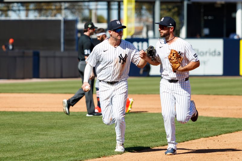 Feb 21, 2026; Tampa, Florida, USA; New York Yankees infielder Max Schuemann (30) and infielder Paul DeJong (18) high five after a double play during the fourth inning in a Spring Training game at George M. Steinbrenner Field. Mandatory Credit: Morgan Tencza-Imagn Images