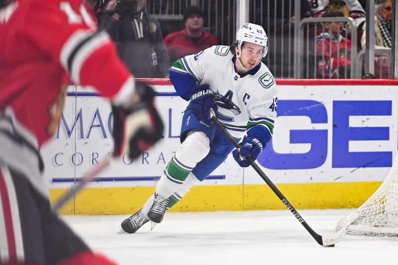 Feb 13, 2024; Chicago, Illinois, USA; Vancouver Canucks defensemen Quinn Hughes (43) carries the puck up ice in the third period against the Chicago Blackhawks at United Center. Mandatory Credit: Jamie Sabau-USA TODAY Sports