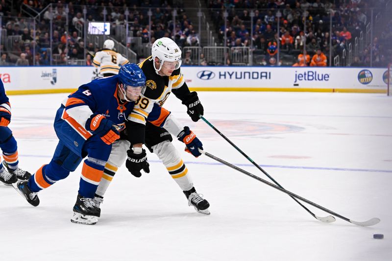 Nov 27, 2024; Elmont, New York, USA;  New York Islanders defenseman Noah Dobson (8) defends against Boston Bruins center Morgan Geekie (39) during the first period at UBS Arena. Mandatory Credit: Dennis Schneidler-Imagn Images