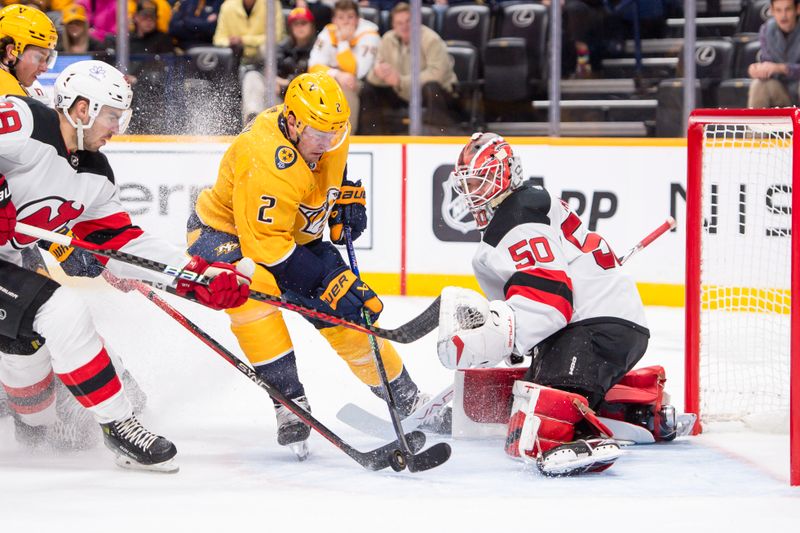 Feb 13, 2024; Nashville, Tennessee, USA;  New Jersey Devils goaltender Nico Daws (50) blocks the shot of Nashville Predators defenseman Luke Schenn (2) during the first period at Bridgestone Arena. Mandatory Credit: Steve Roberts-USA TODAY Sports