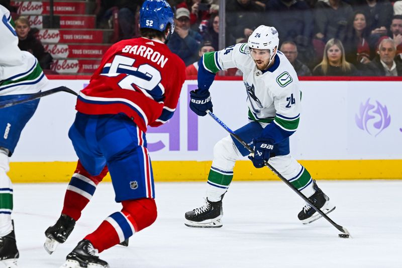 Nov 12, 2023; Montreal, Quebec, CAN; Vancouver Canucks center Pius Suter (24) plays the puck against the Montreal Canadiens during the first period at Bell Centre. Mandatory Credit: David Kirouac-USA TODAY Sports