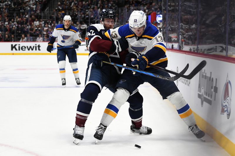 Jan 31, 2025; Denver, Colorado, USA; Colorado Avalanche defenseman Josh Manson (42) and St. Louis Blues right wing Alexey Toropchenko (13) battle for a puck along the boards during the third period at Ball Arena. Mandatory Credit: Christopher Hanewinckel-Imagn Images