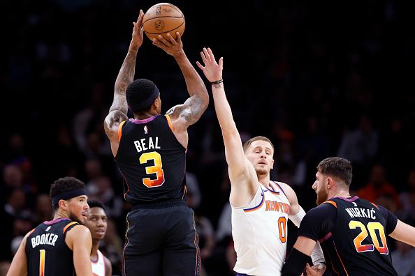 PHOENIX, ARIZONA - DECEMBER 15: Bradley Beal #3 of the Phoenix Suns attempts a three point shot over Donte DiVincenzo #0 of the New York Knicks during the first half at Footprint Center on December 15, 2023 in Phoenix, Arizona. NOTE TO USER: User expressly acknowledges and agrees that, by downloading and or using this photograph, User is consenting to the terms and conditions of the Getty Images License Agreement.  (Photo by Chris Coduto/Getty Images)