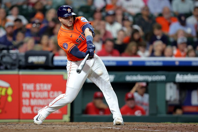 May 9, 2025; Houston, Texas, USA; Houston Astros catcher Yainer Diaz (21) hits a single against the Cincinnati Reds during the sixth inning at Daikin Park. Mandatory Credit: Erik Williams-Imagn Images