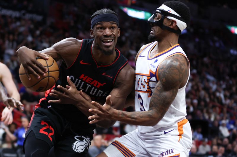 MIAMI, FLORIDA - JANUARY 29: Jimmy Butler #22 of the Miami Heat drives against Bradley Beal #3 of the Phoenix Suns during the third quarter of the game at Kaseya Center on January 29, 2024 in Miami, Florida. NOTE TO USER: User expressly acknowledges and agrees that, by downloading and or using this photograph, User is consenting to the terms and conditions of the Getty Images License Agreement. (Photo by Megan Briggs/Getty Images)