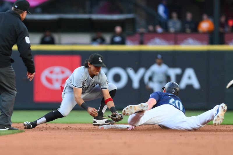 Jun 12, 2024; Seattle, Washington, USA; Chicago White Sox second baseman Nicky Lopez (8) tags Seattle Mariners left fielder Luke Raley (20) out during a steal attempt in the fourth inning at T-Mobile Park. Mandatory Credit: Steven Bisig-USA TODAY Sports