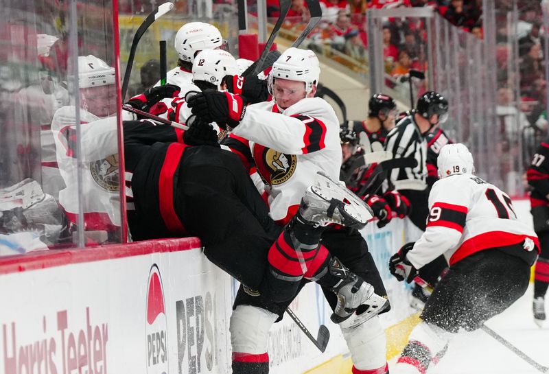 Nov 16, 2024; Raleigh, North Carolina, USA;  Ottawa Senators left wing Brady Tkachuk (7) checks Carolina Hurricanes defenseman Jaccob Slavin (74) during the second period at Lenovo Center. Mandatory Credit: James Guillory-Imagn Images