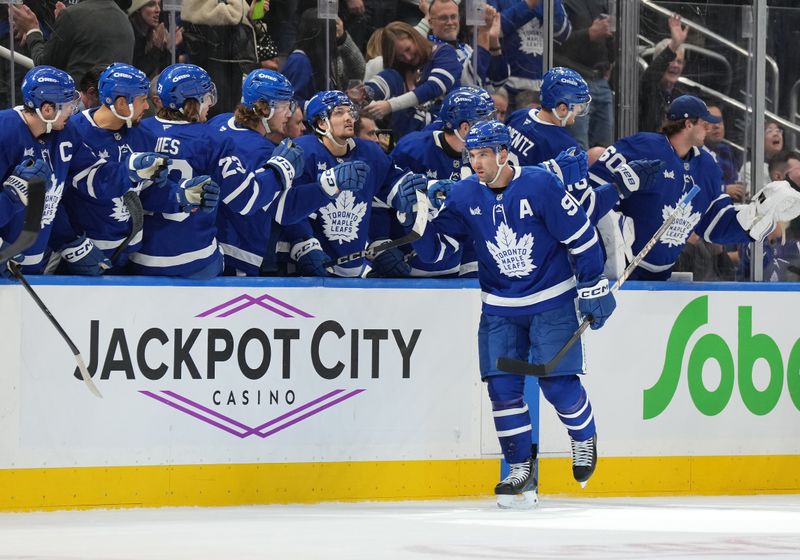 Dec 6, 2024; Toronto, Ontario, CAN; Toronto Maple Leafs center John Tavares (91) celebrates at the bench after scoring a goal against the Washington Capitals during the second period at Scotiabank Arena. Mandatory Credit: Nick Turchiaro-Imagn Images