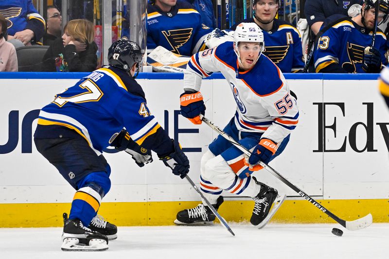 Feb 15, 2024; St. Louis, Missouri, USA;  Edmonton Oilers left wing Dylan Holloway (55) controls the puck as St. Louis Blues defenseman Torey Krug (47) defends during the third period at Enterprise Center. Mandatory Credit: Jeff Curry-USA TODAY Sports