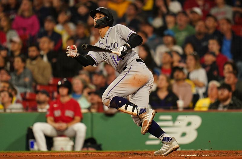 Jun 14, 2023; Boston, Massachusetts, USA; Colorado Rockies shortstop Ezequiel Tovar (14) hits a sacrifice fly ball to left field to drive in a run against the Boston Red Sox in the sixth inning at Fenway Park. Mandatory Credit: David Butler II-USA TODAY Sports