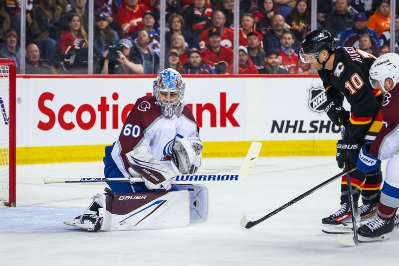 Mar 12, 2024; Calgary, Alberta, CAN; Colorado Avalanche goaltender Justus Annunen (60) makes a save against Calgary Flames center Jonathan Huberdeau (10) during the second period at Scotiabank Saddledome. Mandatory Credit: Sergei Belski-USA TODAY Sports