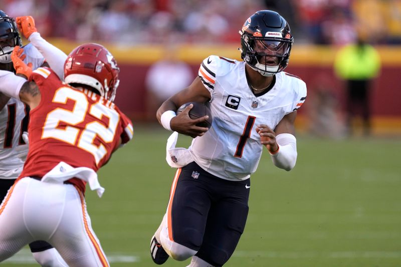 Chicago Bears quarterback Justin Fields (1) runs with the ball as Kansas City Chiefs cornerback Trent McDuffie (22) defends during the second half of an NFL football game Sunday, Sept. 24, 2023, in Kansas City, Mo. (AP Photo/Charlie Riedel)