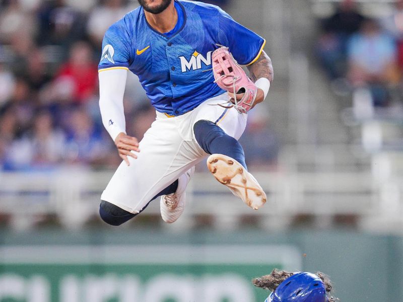 May 23, 2025; Minneapolis, Minnesota, USA; Minnesota Twins shortstop Carlos Correa (4) jumps over the Kansas City Royals second base Jonathan India (6) in the seventh inning at Target Field. Mandatory Credit: Brad Rempel-Imagn Images