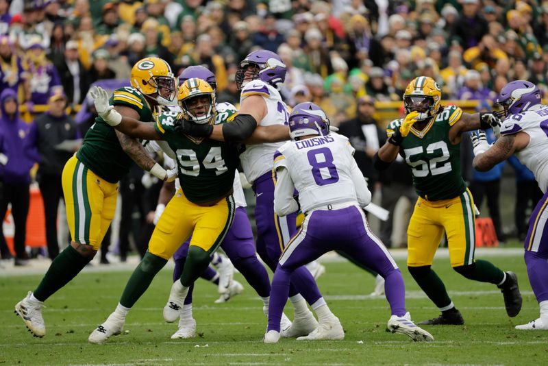 Minnesota Vikings quarterback Kirk Cousins (8) tries to elude Green Bay Packers defensive end Karl Brooks (94) during an NFL football game Sunday, Oct. 29, 2023, in Green Bay, Wis. (AP Photo/Mike Roemer)