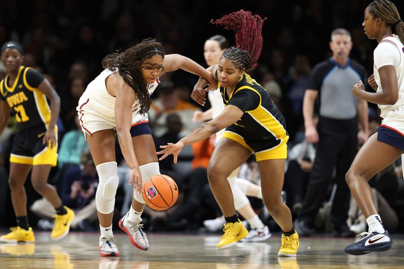 Dec 20, 2025; Brooklyn, New York, USA; UConn Huskies forward Sarah Strong (21) and Iowa Hawkeyes guard Journey Houston (8) compete for the ball during the first half at Barclays Center. Mandatory Credit: Pamela Smith-Imagn Images
