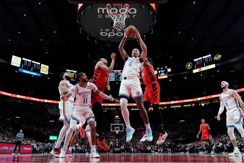 PORTLAND, OREGON - JANUARY 26: Jaylin Williams #6 of the Oklahoma City Thunder comes down with a rebound against Dalano Banton #5 and Robert Williams III #35 of the Portland Trail Blazers during the first half at Moda Center on January 26, 2025 in Portland, Oregon. NOTE TO USER: User expressly acknowledges and agrees that, by downloading and or using this photograph, User is consenting to the terms and conditions of the Getty Images License Agreement. (Photo by Soobum Im/Getty Images)