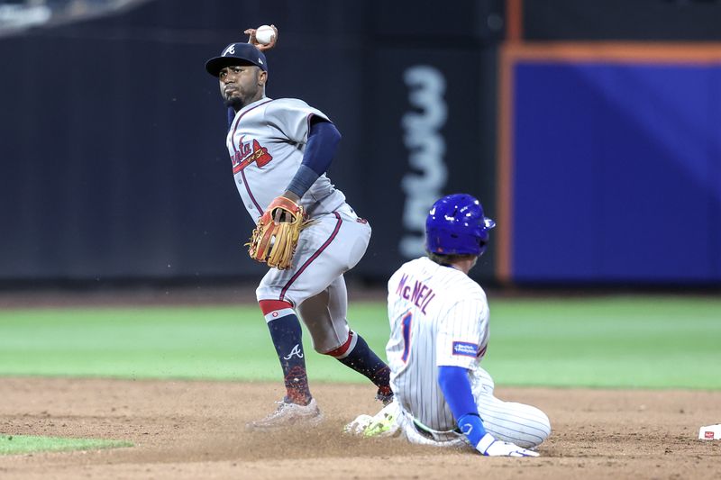 Jun 25, 2025; New York City, New York, USA;  Atlanta Braves second baseman Ozzie Albies (1) throws past New York Mets center fielder Jeff McNeil (1) attempting to complete a double play in the fifth inning at Citi Field. Mandatory Credit: Wendell Cruz-Imagn Images