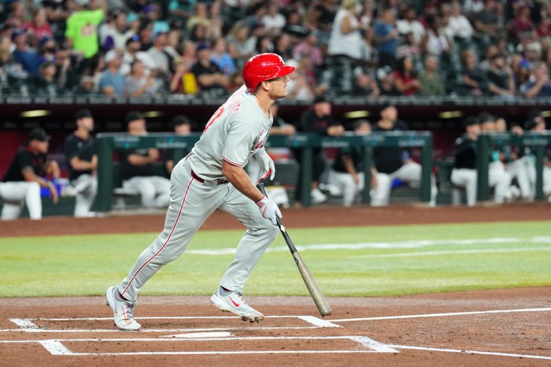 Sep 20, 2025; Phoenix, Arizona, USA; Philadelphia Phillies catcher J.T. Realmuto (10) hits a sacrifice fly RBI against the Arizona Diamondbacks during the first inning at Chase Field. Mandatory Credit: Joe Camporeale-Imagn Images