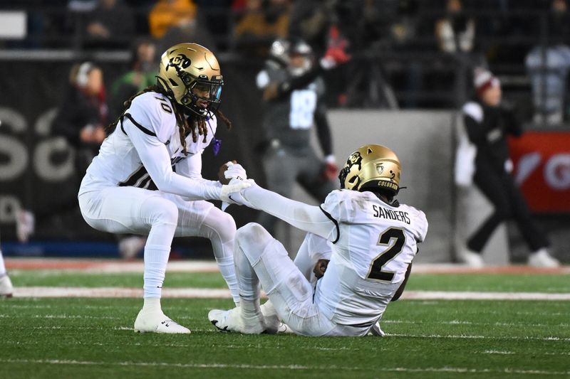 Nov 17, 2023; Pullman, Washington, USA; Colorado Buffaloes quarterback Shedeur Sanders (2) is helped up be teammate Colorado Buffaloes wide receiver Xavier Weaver (10) after a play against the Washington State Cougars in the first half at Gesa Field at Martin Stadium. Mandatory Credit: James Snook-USA TODAY Sports