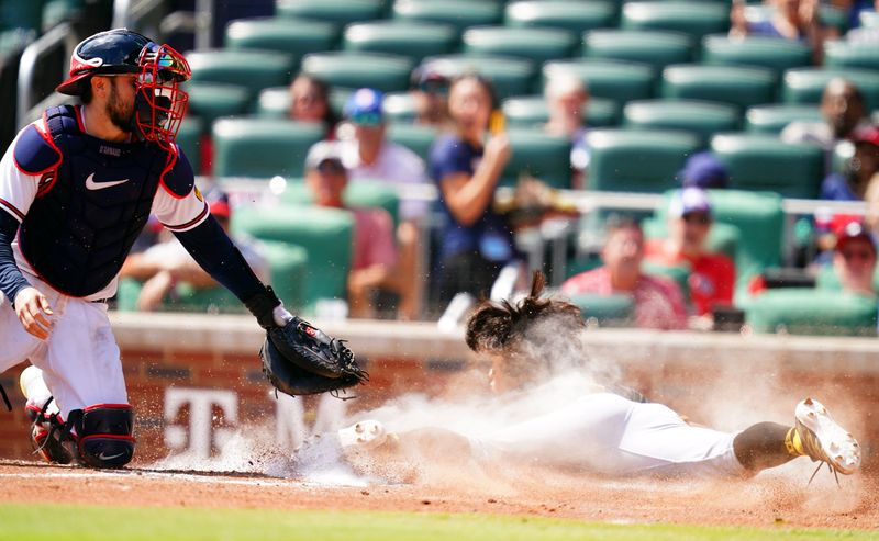 Sep 10, 2023; Cumberland, Georgia, USA; Atlanta Braves catcher Travis d'Arnaud (16) bobbles the throw to home plate as Pittsburgh Pirates second baseman Ji Hwan Bae (3) slides safely into home for a run during the sixth inning at Truist Park. Mandatory Credit: John David Mercer-USA TODAY Sports