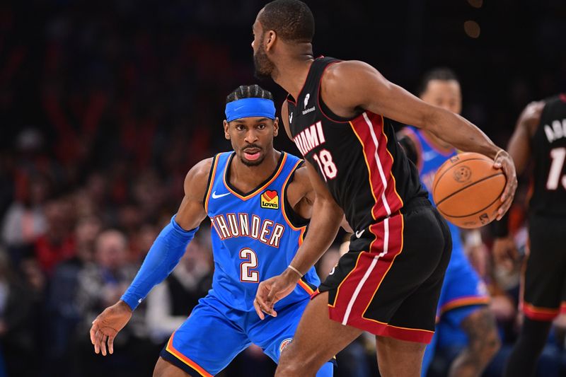 OKLAHOMA CITY, OKLAHOMA - FEBRUARY 12: Shai Gilgeous-Alexander #2 of the Oklahoma City Thunder looks to defend Alec Burks #18 of the Miami Heat during the first half at Paycom Center on February 12, 2025 in Oklahoma City, Oklahoma. NOTE TO USER: User expressly acknowledges and agrees that, by downloading and or using this photograph, User is consenting to the terms and conditions of the Getty Images License Agreement. (Photo by Joshua Gateley/Getty Images)