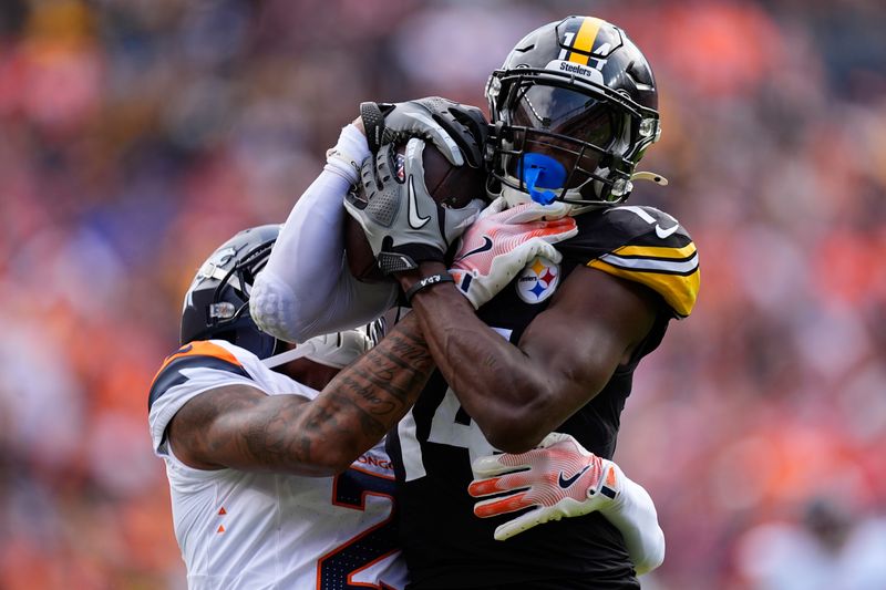 Pittsburgh Steelers wide receiver George Pickens (14) catches a pass against Denver Broncos cornerback Pat Surtain II (2) during the first half of an NFL football game, Sunday, Sept. 15, 2024, in Denver. (AP Photo/David Zalubowski)