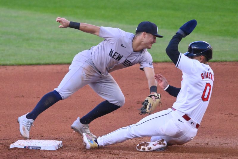 Apr 13, 2024; Cleveland, Ohio, USA; Cleveland Guardians second baseman Andres Gimenez (0) is forced out at second base by New York Yankees shortstop Anthony Volpe (11) in the fourth inning at Progressive Field. Mandatory Credit: David Richard-USA TODAY Sports