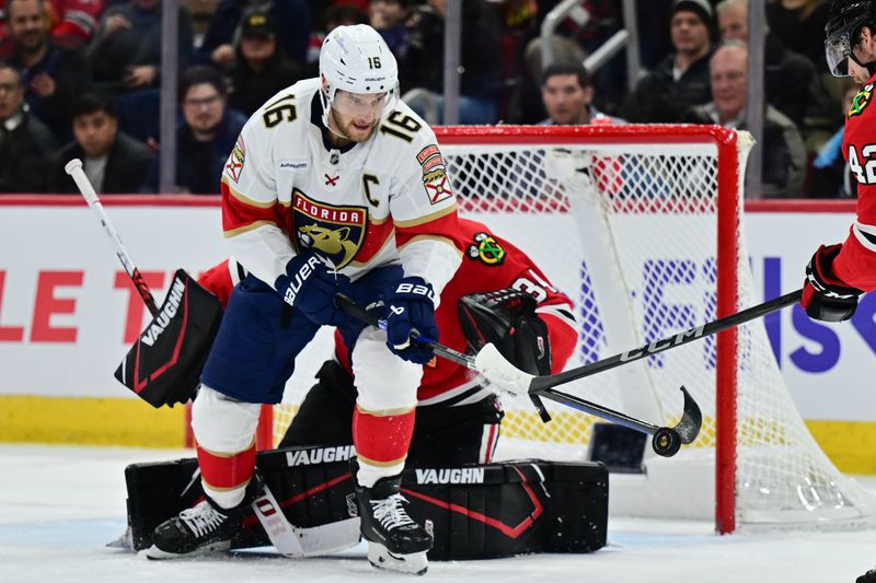 Nov 21, 2024; Chicago, Illinois, USA; Florida Panthers center Aleksander Barkov (16) plays the puck as Chicago Blackhawks goaltender Petr Mrazek (34) defends his goal during the first period at the United Center. Mandatory Credit: Daniel Bartel-Imagn Images