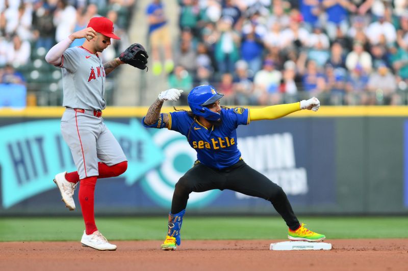 May 31, 2024; Seattle, Washington, USA; Seattle Mariners shortstop J.P. Crawford (3) celebrates hitting a double while Los Angeles Angels shortstop Zach Neto (9) watches during the first inning at T-Mobile Park. Mandatory Credit: Steven Bisig-USA TODAY Sports